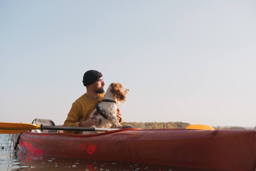Man with dog in a kayak.